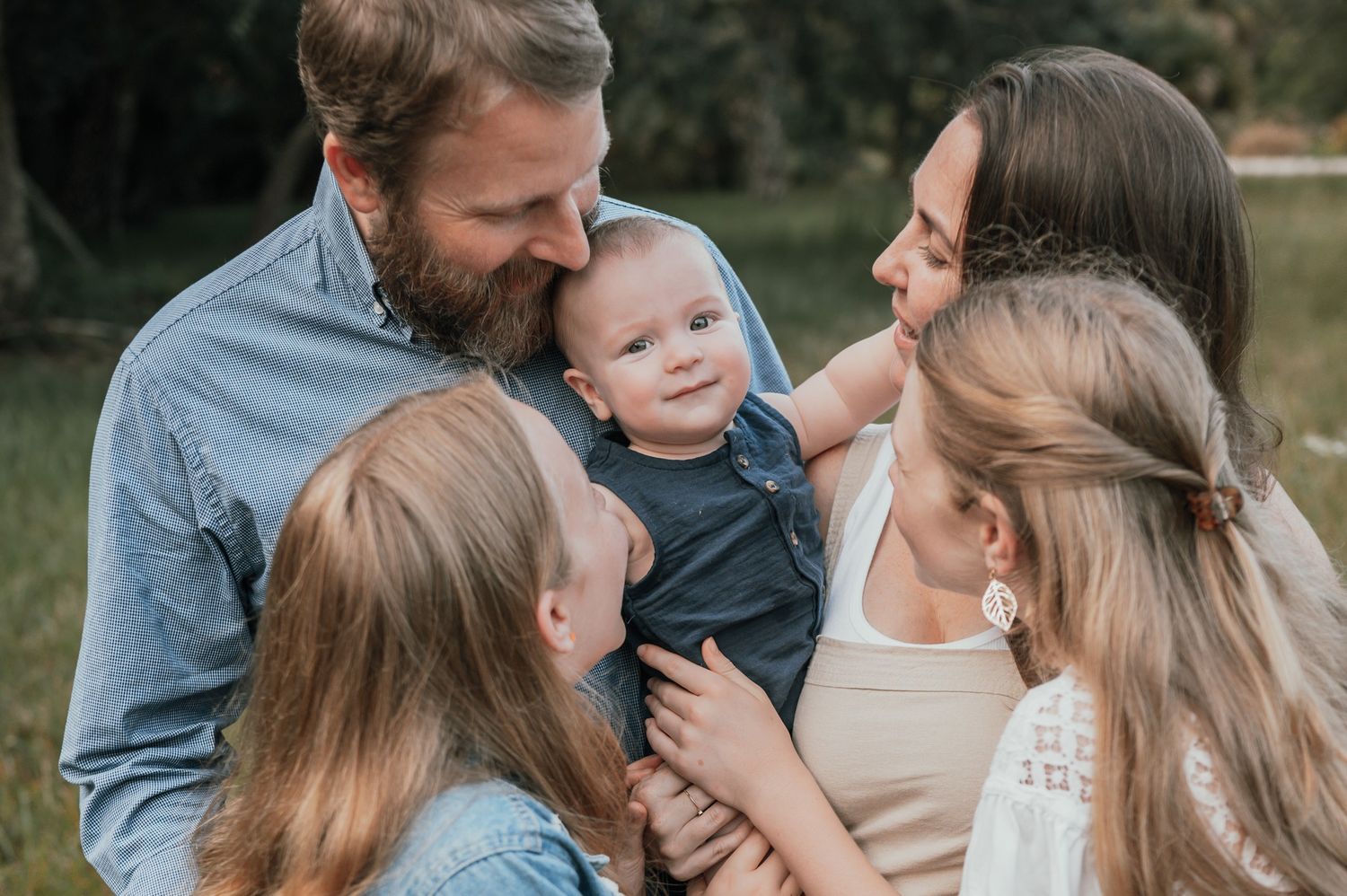 Family smiling down at baby in park field candid moment photoshoot session Palm Bay Melbourne Cocoa Beach Florida Brevard County
