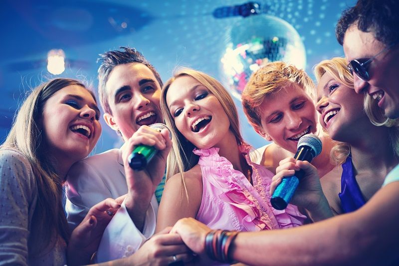 Crowd enjoying a nightclub party under blue lighting and disco effects.