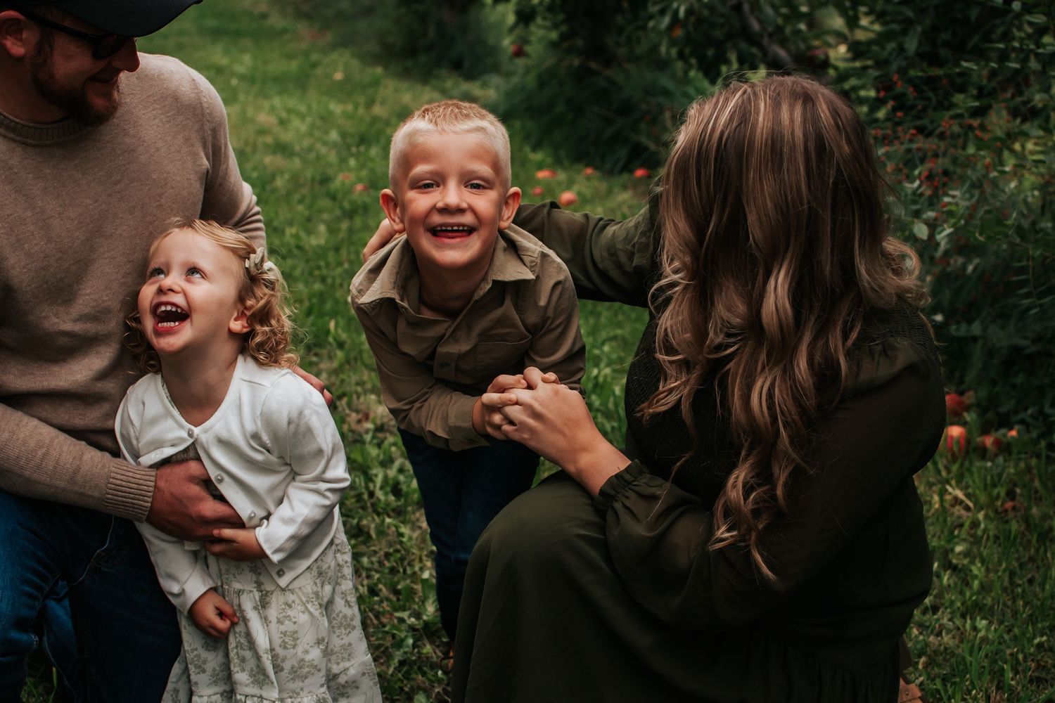 A joyful family sharing laughs together outdoors on a sunny day in Tri Cities, Washington.