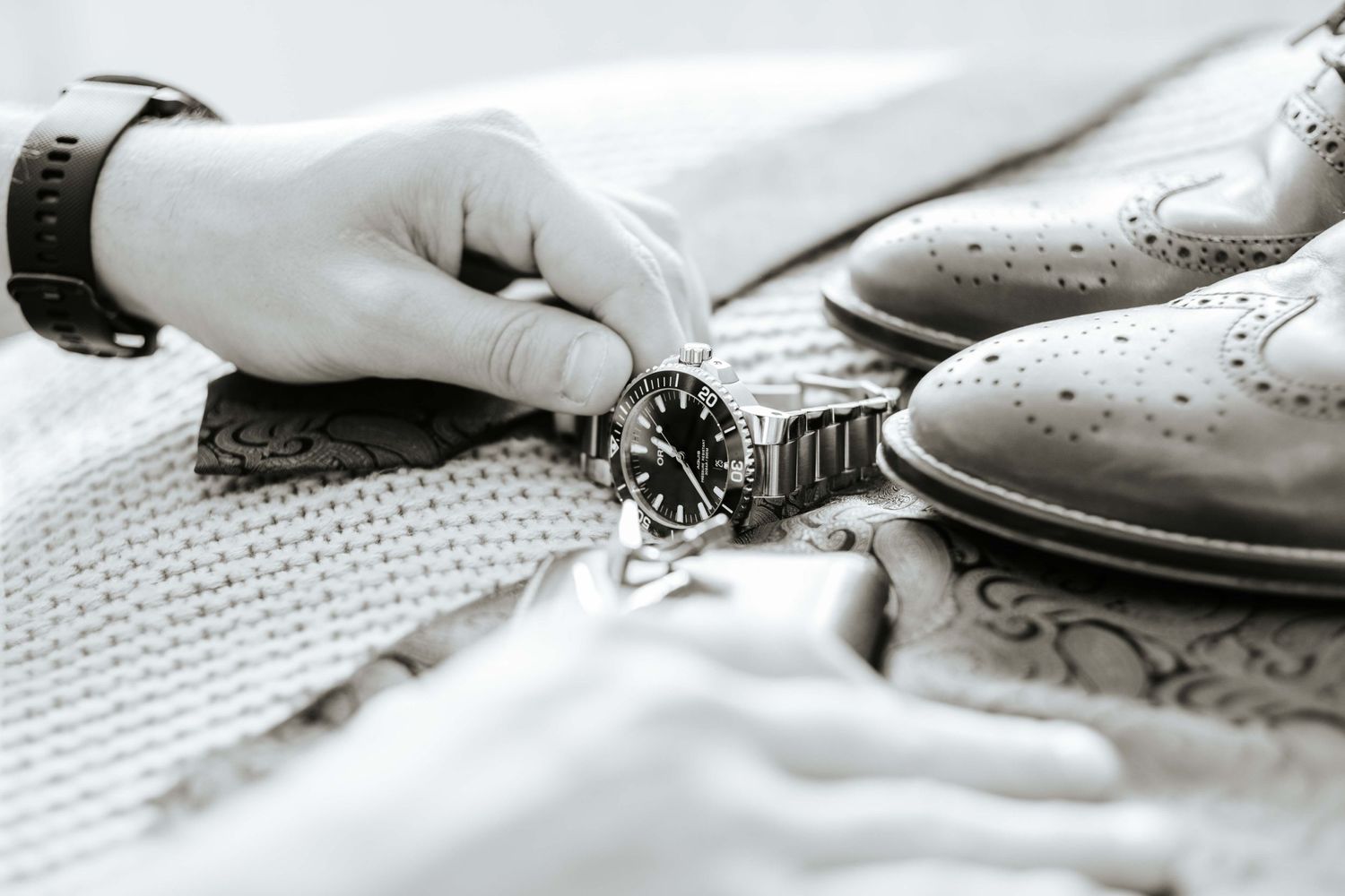 Groom prepping shoes and watch for wedding day