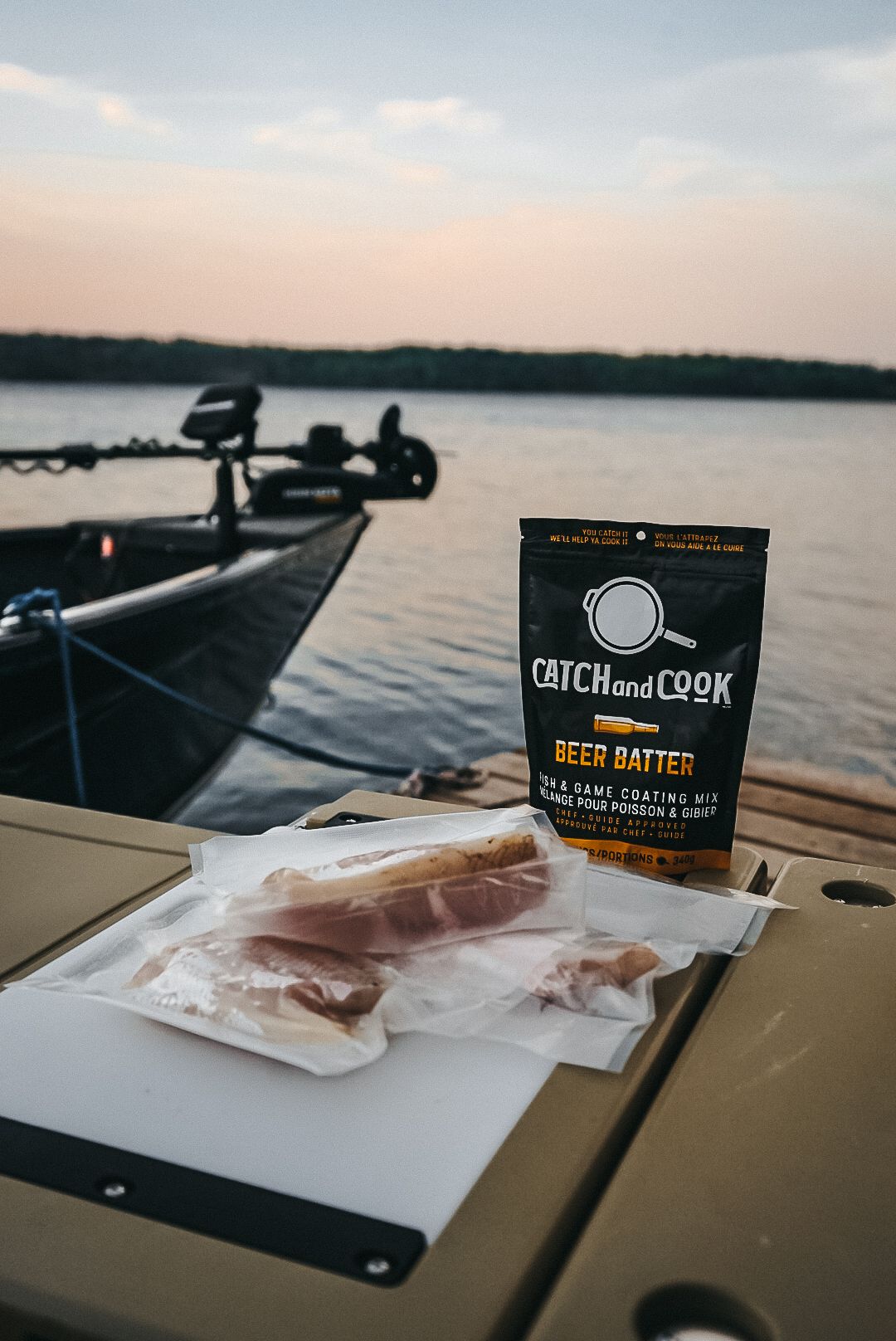 Fishing boat at sunset with Catch and Cook beer batter mix and raw fish fillets.