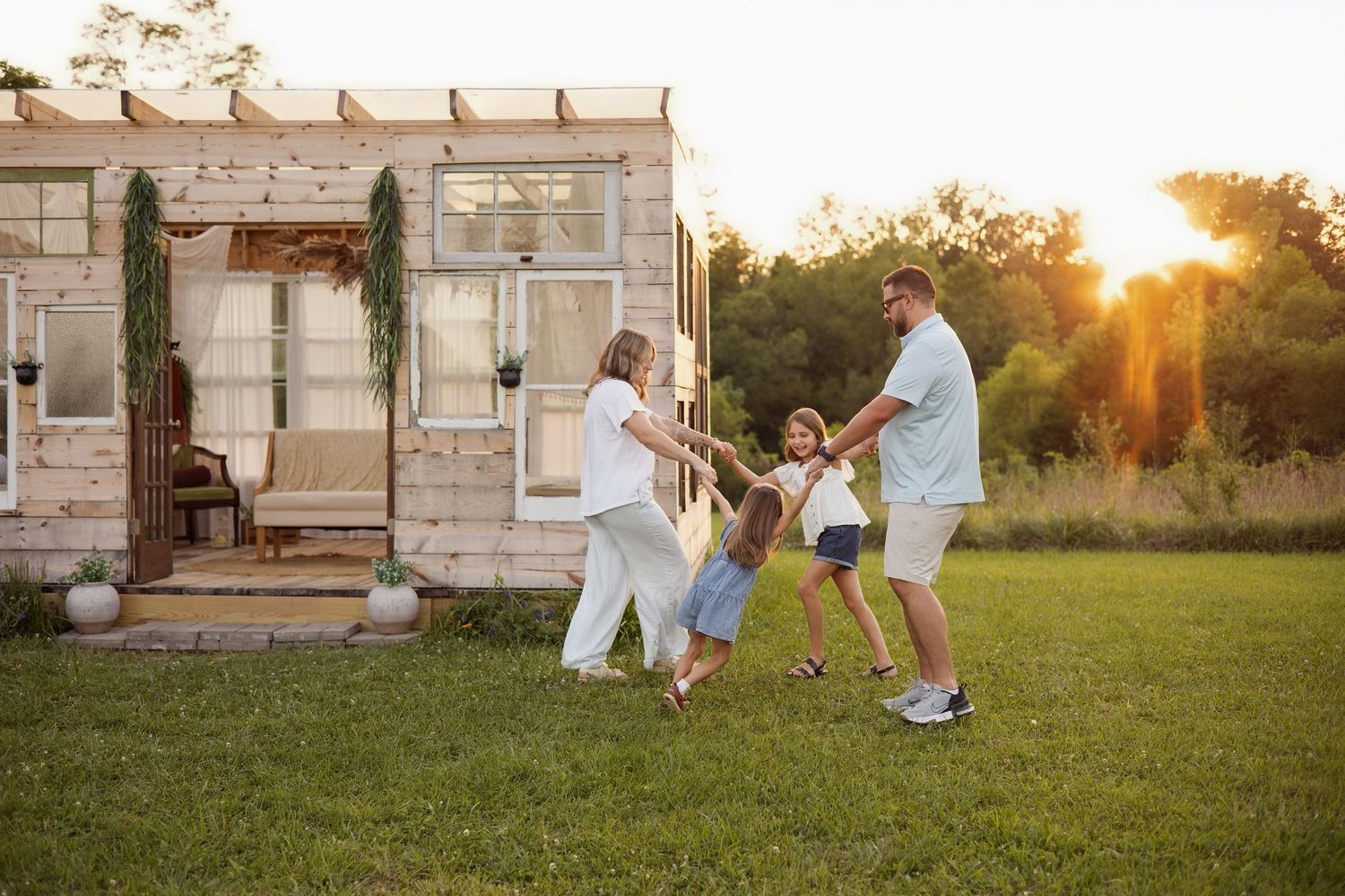 Two children hugging a maternity dress in an outdoor setting at sunset.