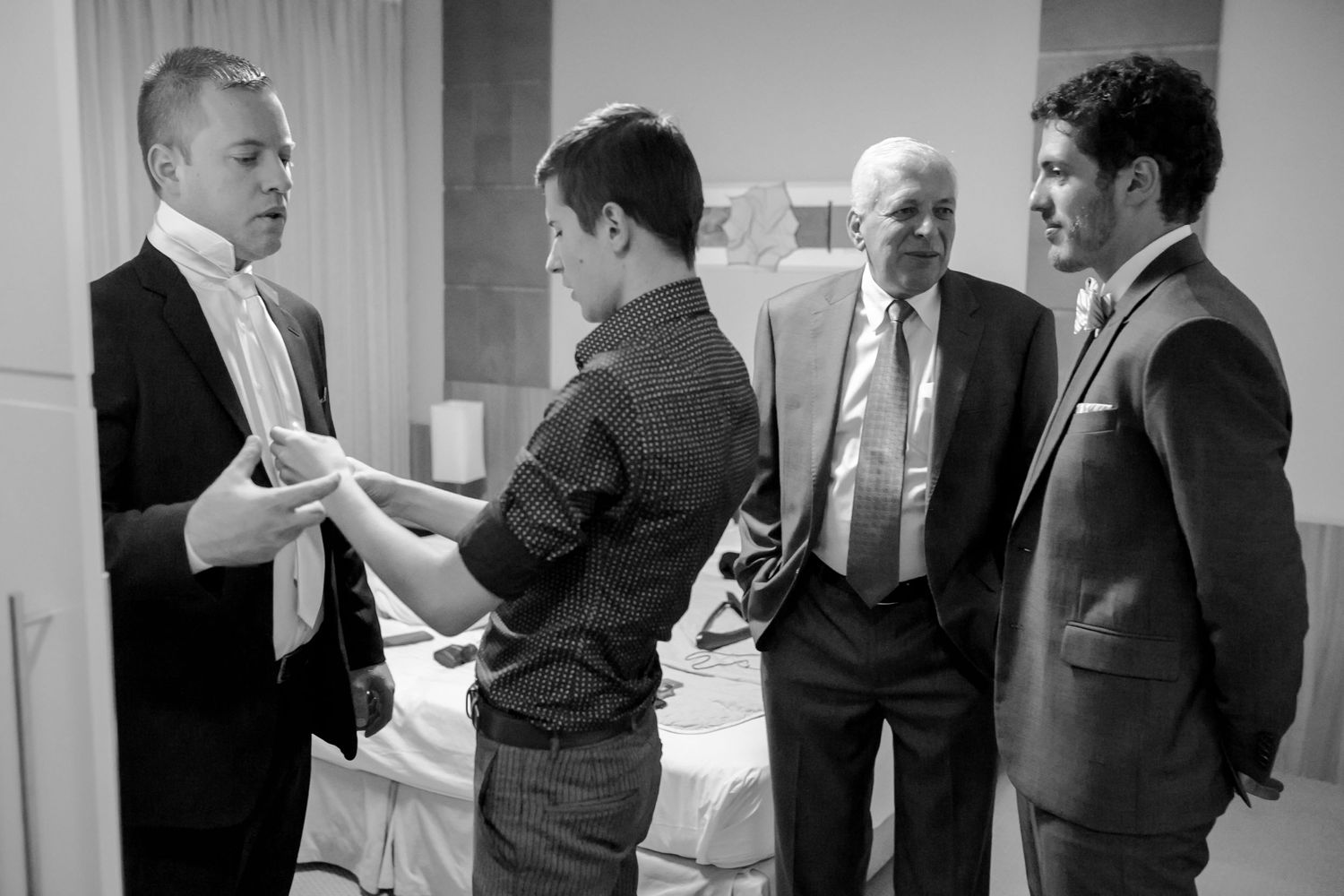 Four men in suits having a business conversation in a formal setting.