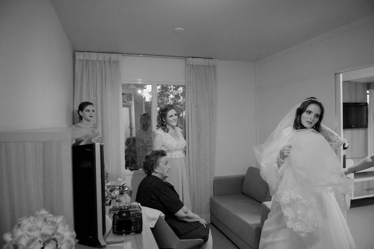 Candid black and white photo of wedding preparation scene in a bridal suite.