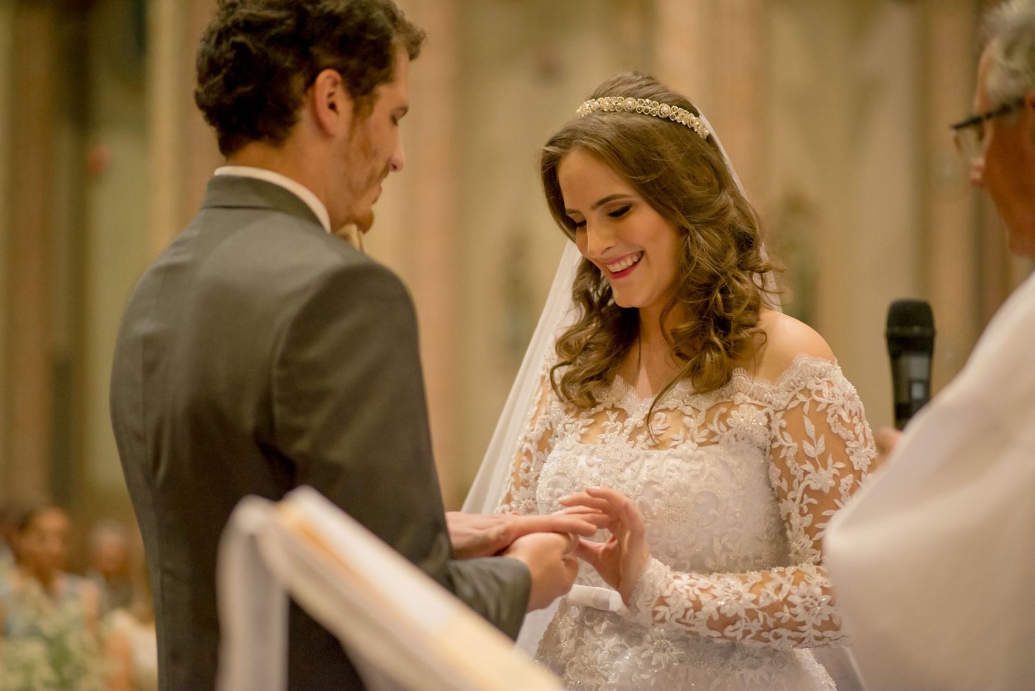 Exchange of rings during traditional Catholic church wedding ceremony.
