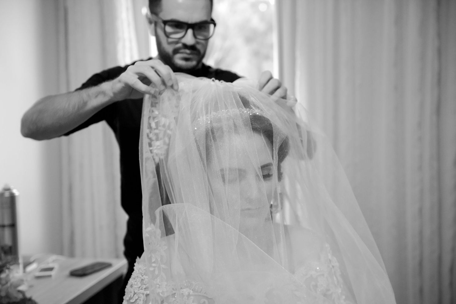 A wedding veil being carefully adjusted during bridal preparation.