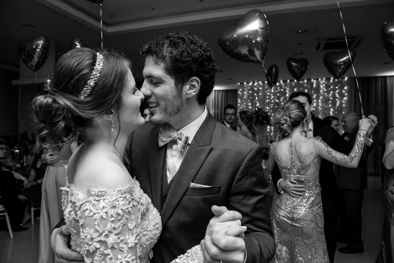 Wedding couple dancing together at their reception with party lights and decor.