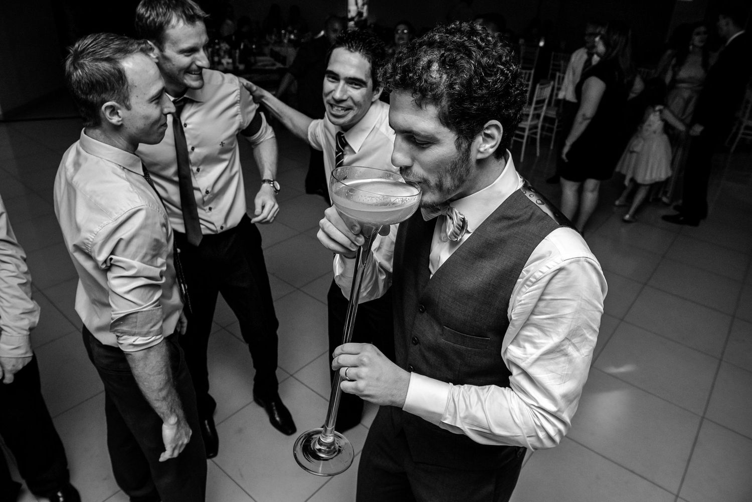 Wedding reception guests laughing and dancing together on the dance floor.