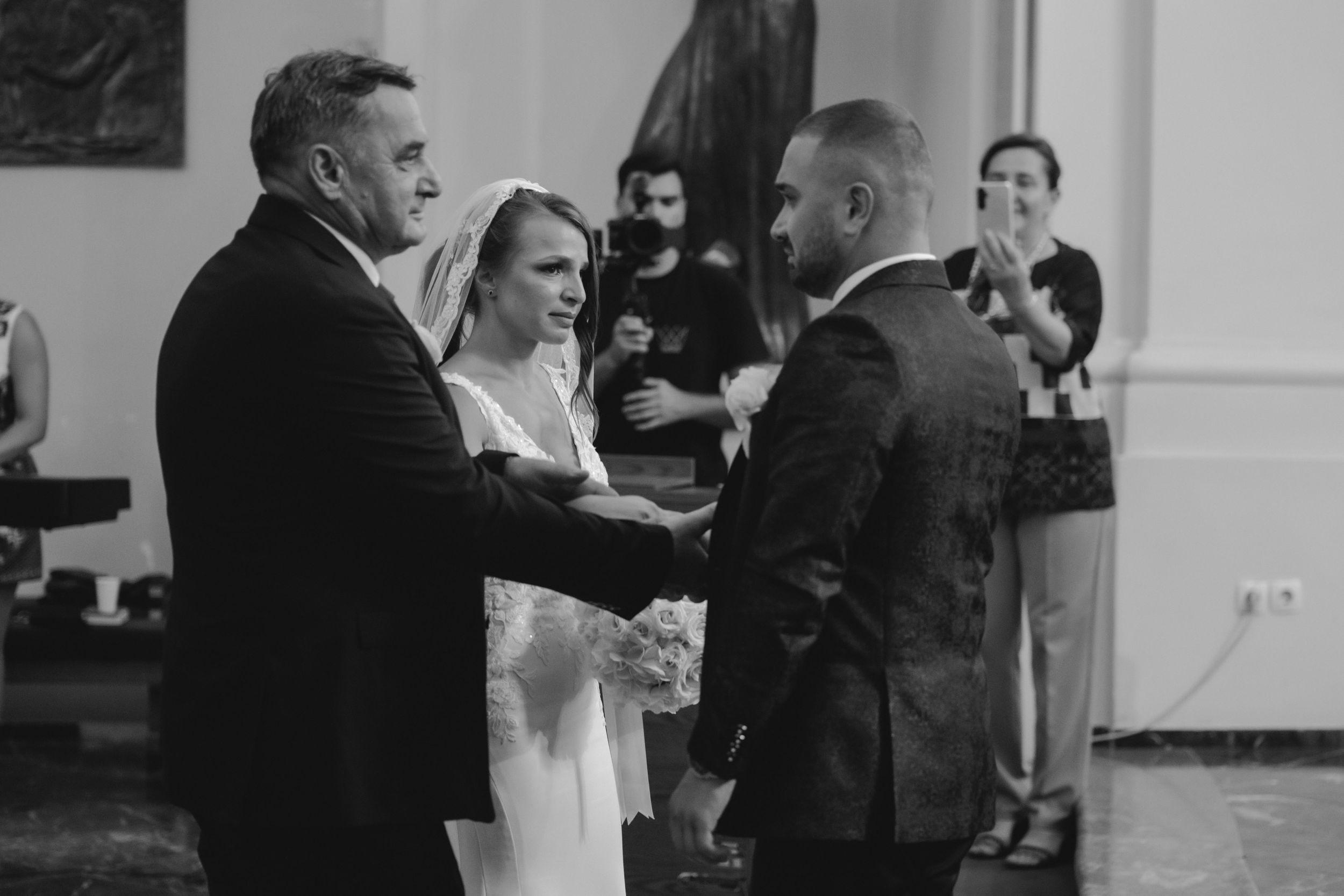 An emotional wedding ceremony moment captured in black and white inside a church.