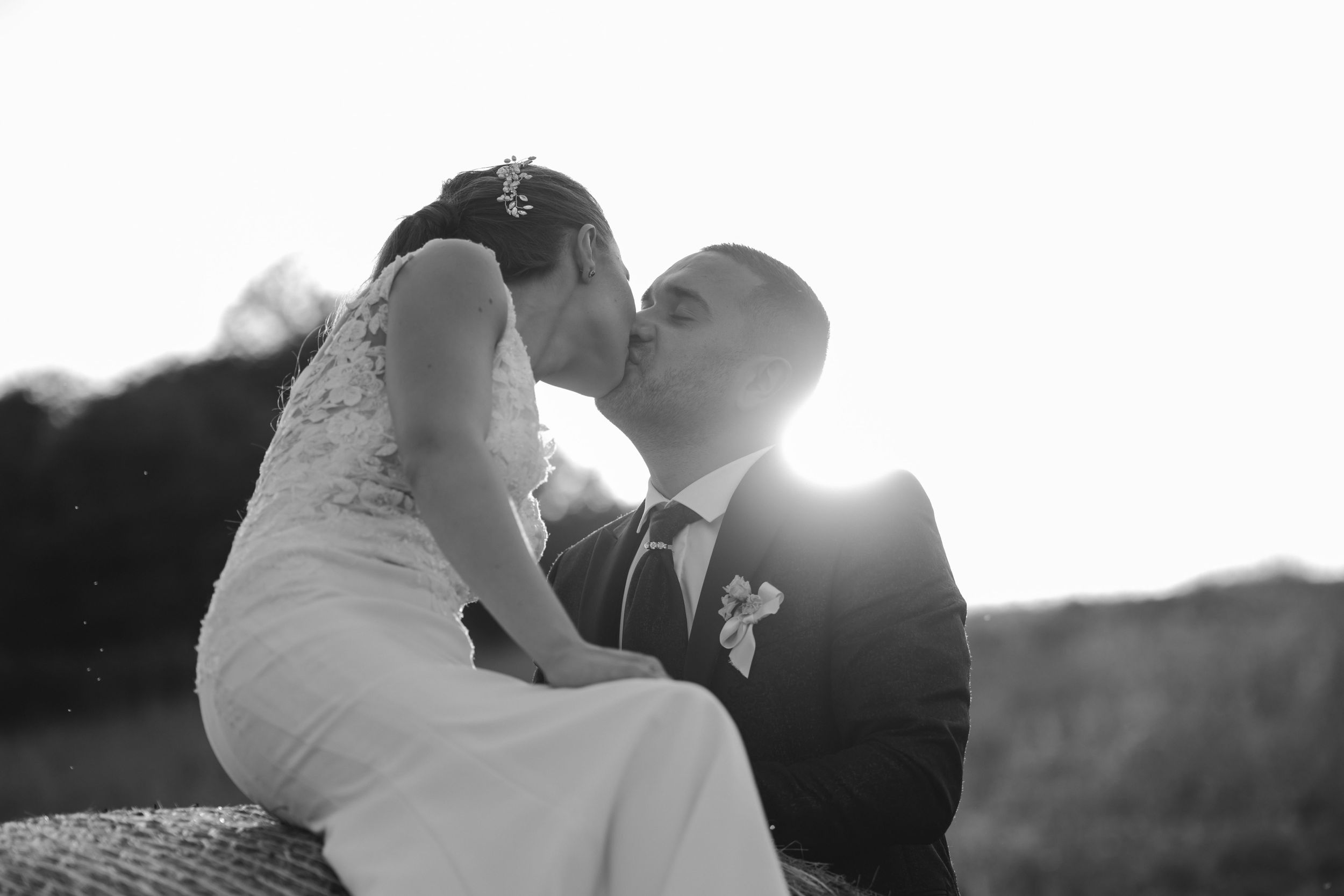 Black and white silhouette of newlyweds sharing an intimate moment during golden hour.