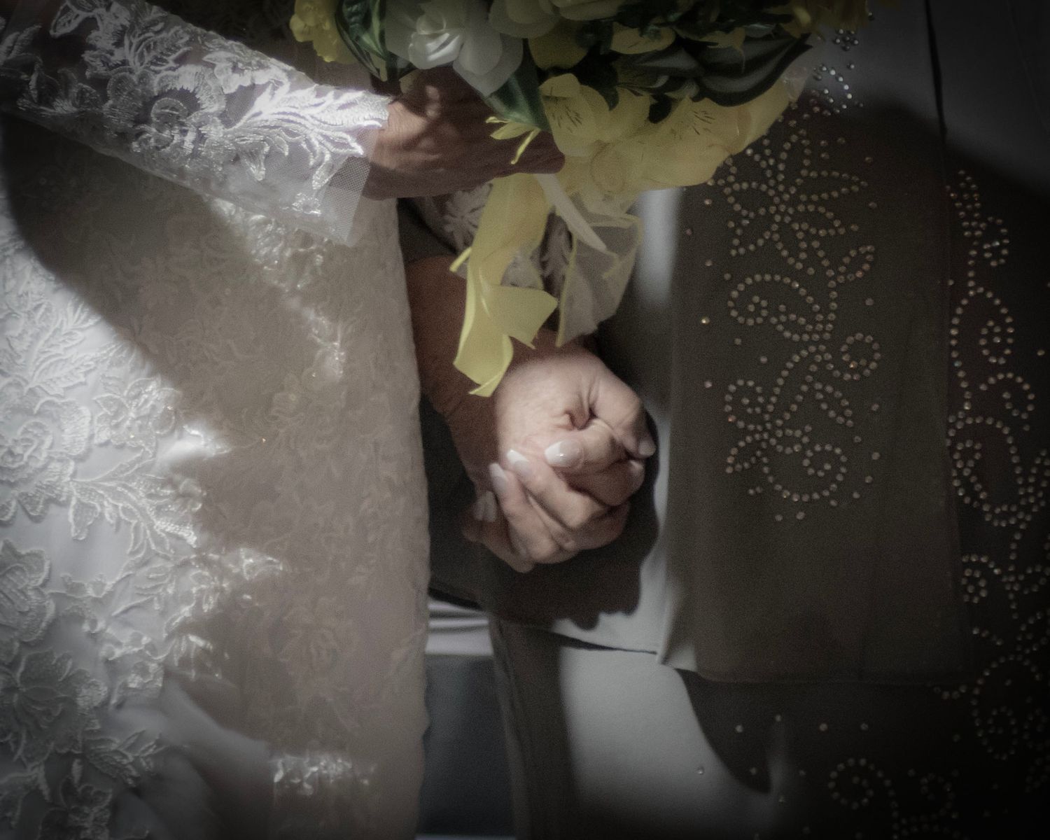 An artistic overhead wedding portrait showcasing delicate lace details and floral elements.