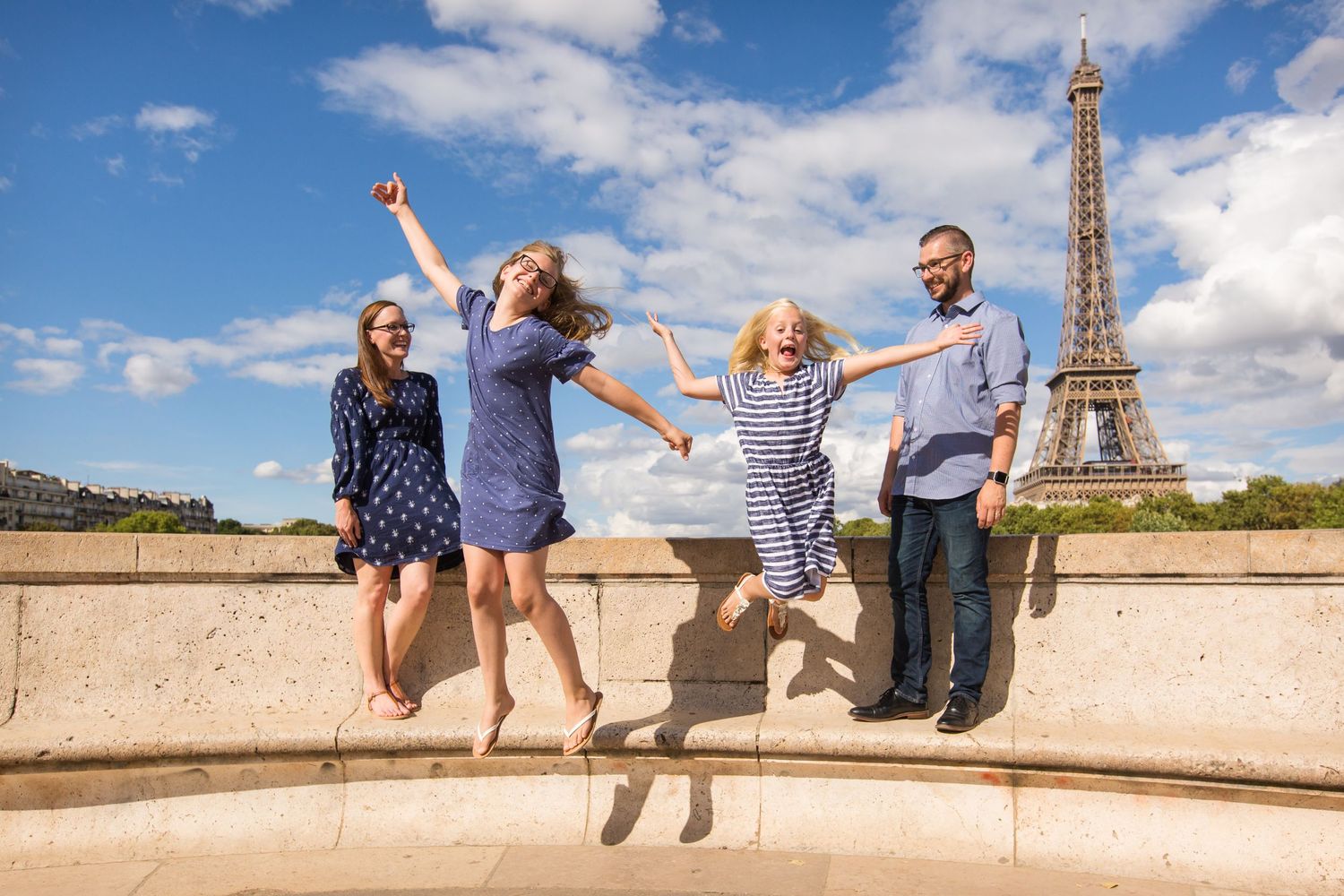 Happy kids laughing during a family photoshoot at the Eiffel Tower by Picmytrip Paris