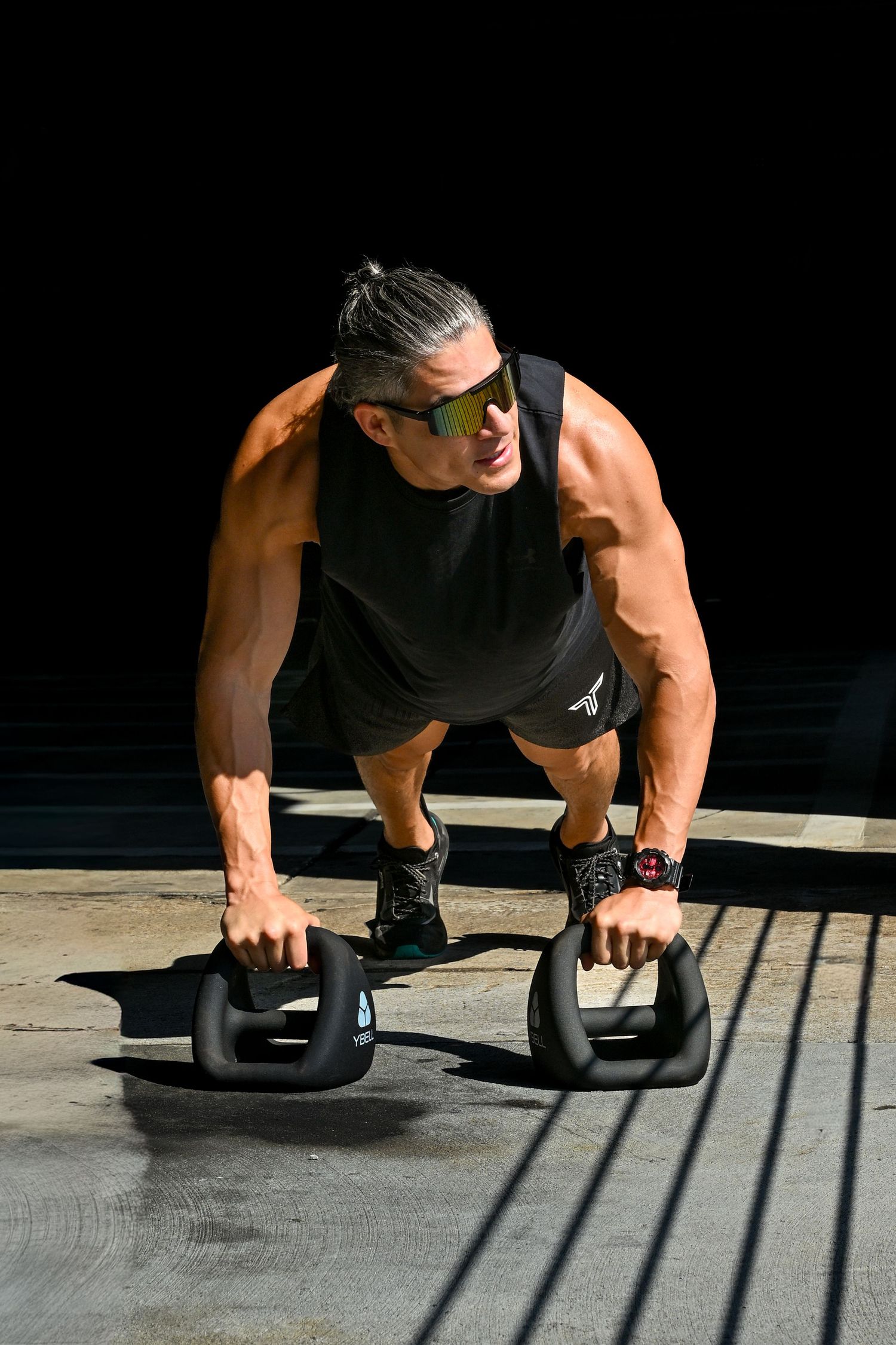 Person performing a pushup exercise with kettlebells on a sunlit floor showing progressive movement sequence in steps.