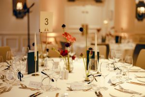 Elegant formal dining table setting with wine glasses and floral centerpiece.