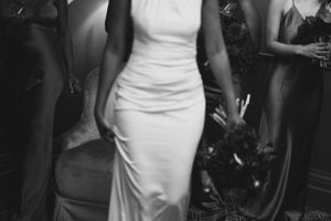 Black and white photo of an elegant fitted white gown at a formal event.