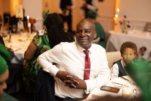 A celebratory scene at a formal dinner with guests in festive attire.