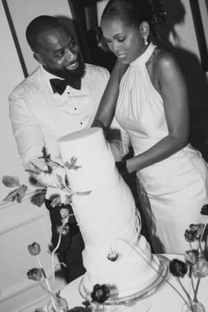 Couple in formal wear cutting their wedding cake together.
