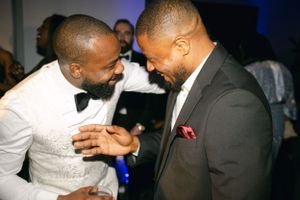 Two guests sharing a joyful moment during a wedding reception.