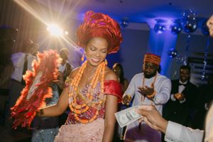 Dancer in traditional African attire performs at celebration event.