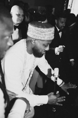 Guest in traditional white attire at formal celebration.