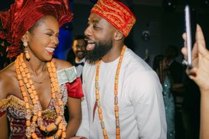Couple in traditional Nigerian wedding attire share a happy moment at their celebration.