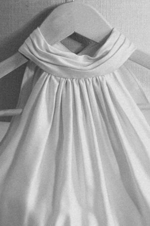 Close-up of white wedding dress neckline with elegant draped fabric detail.