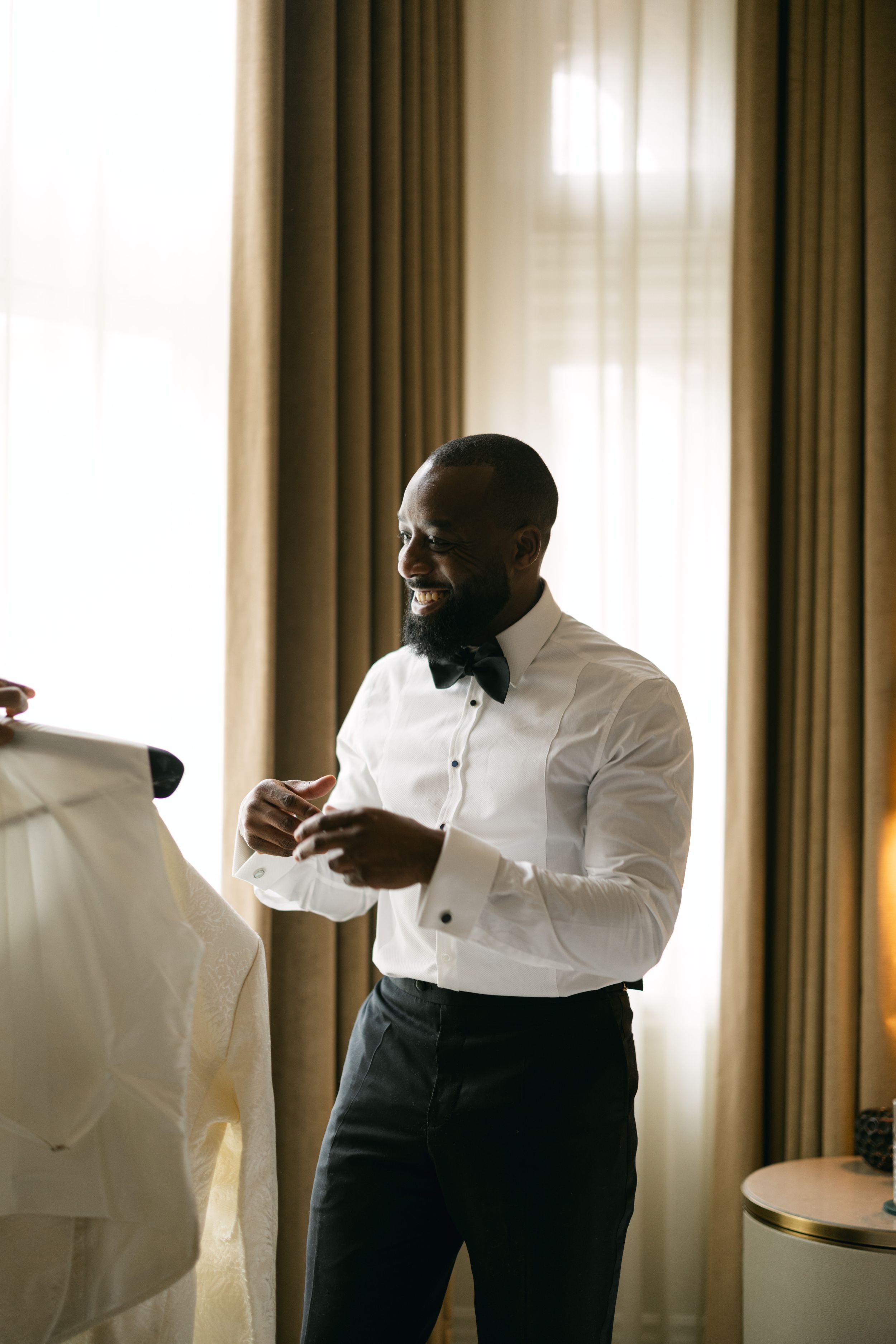 Elegant formal wear preparation scene in natural window light.
