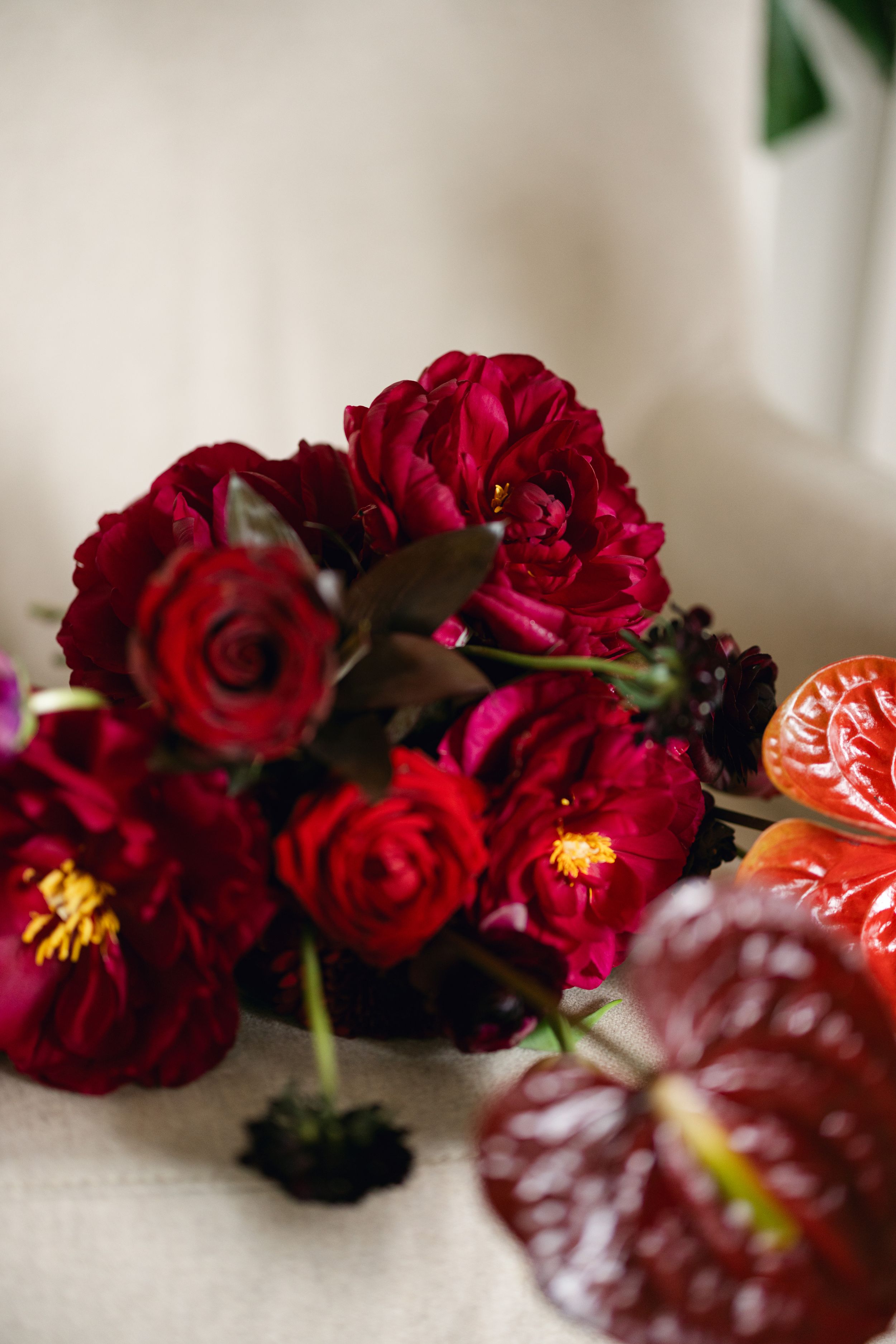 Vibrant red roses and anthurium flowers arranged in an elegant wedding bouquet.
