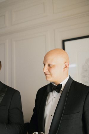 Man in black tuxedo and bow tie at formal event.