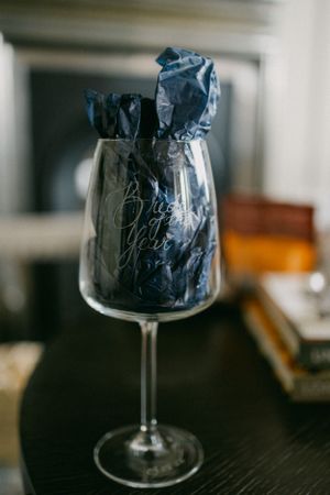 Blue gift bags arranged in a wine glass with elegant presentation.