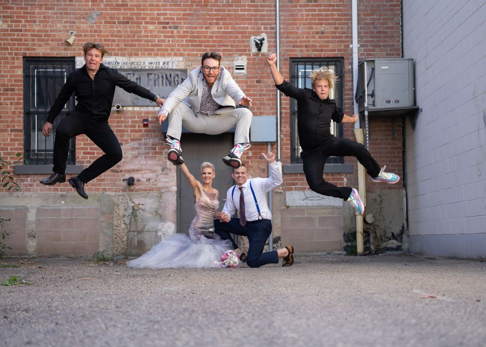 A sequence of wedding photos showing playful jumping poses against an industrial brick wall backdrop.