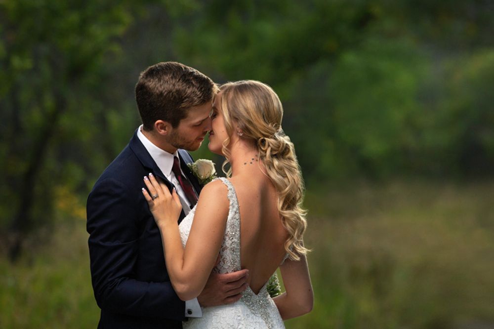 Romantic outdoor wedding photography session in a lush green natural setting.