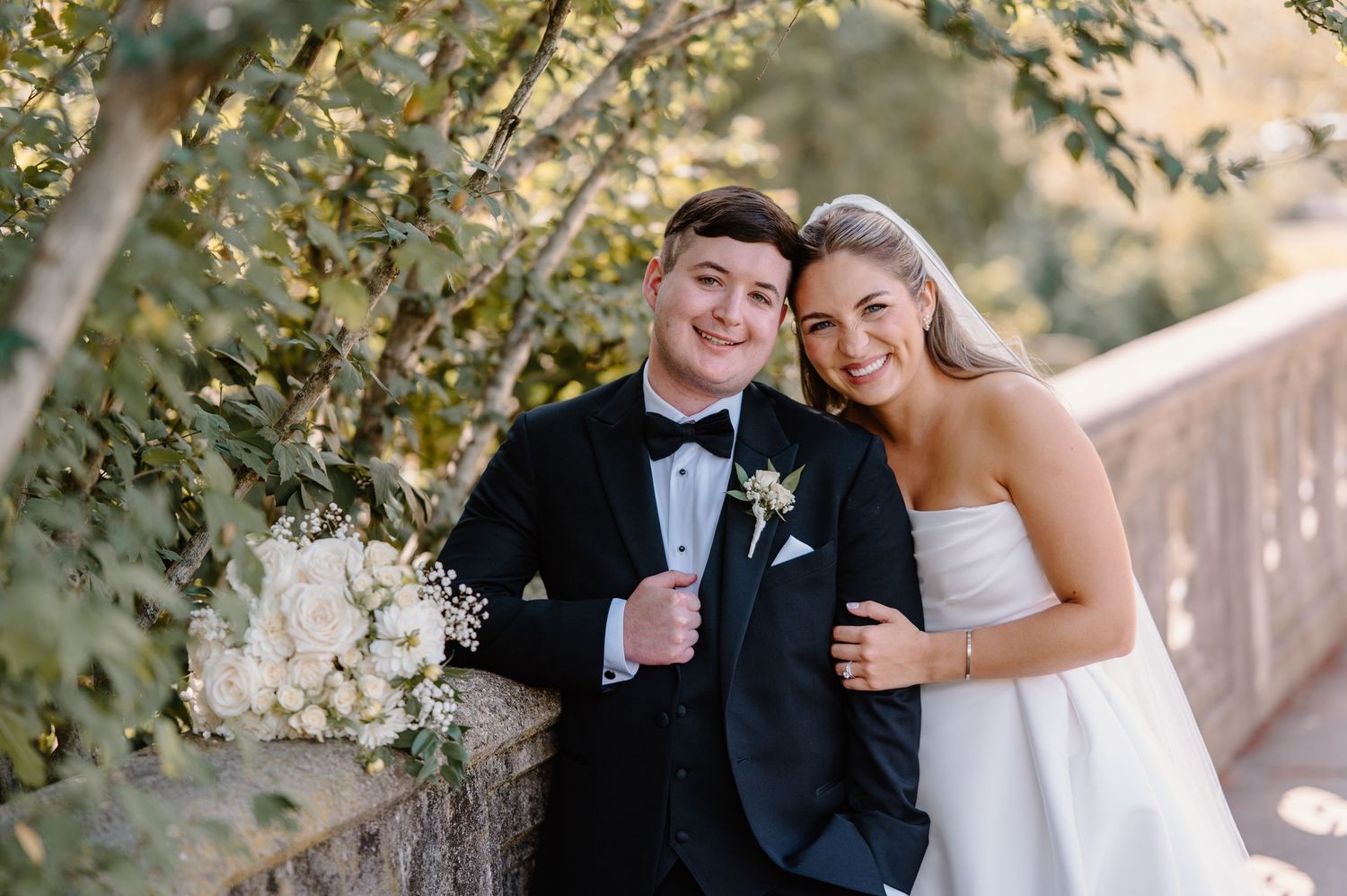 A dramatic wedding portrait on rocky terrain with cloudy skies and a dog.