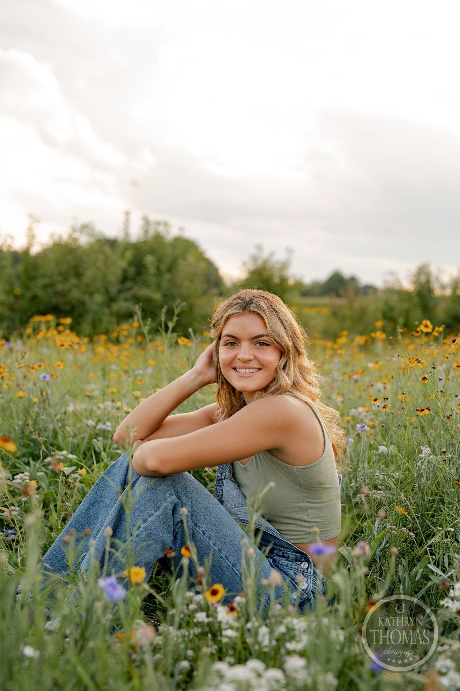 A casual summer portrait in a wildflower field with someone wearing denim overalls.