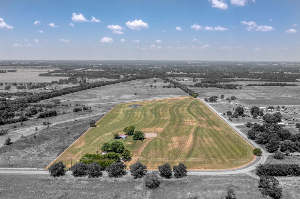 Aerial view of cultivated farmland with curved field patterns highlighted in selective coloring.