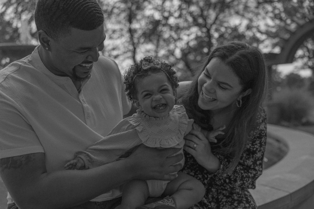 Black and white portrait of a family sharing joyful moments outdoors.