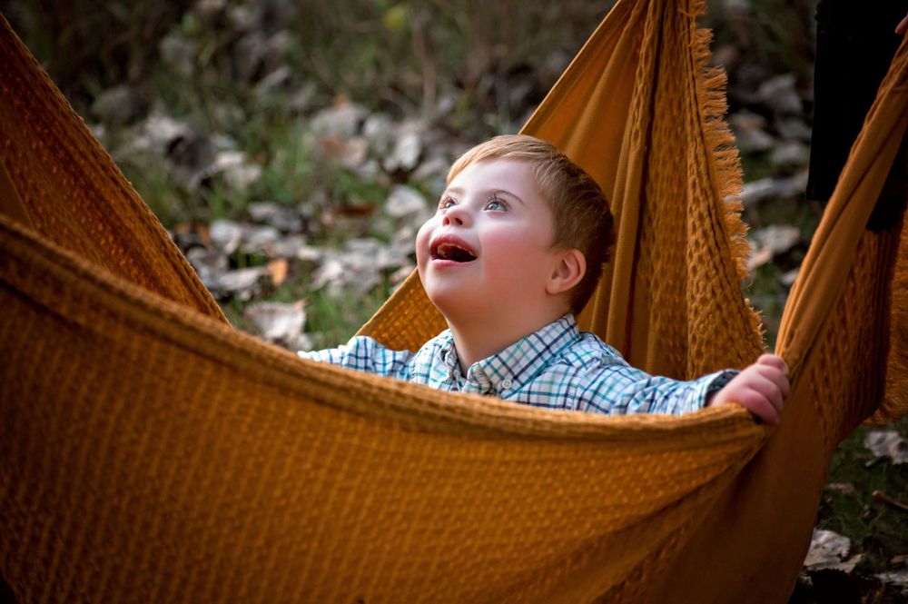 oung boy playing or exploring outdoors in a lush green field, wearing casual clothing – outdoor child portrait session in Woodbury MN