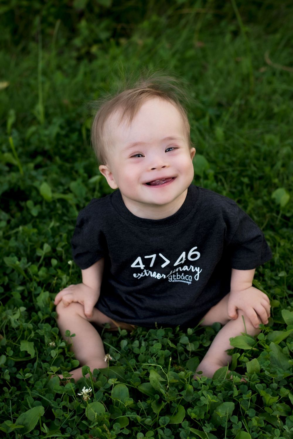 Young boy playing or exploring outdoors in a lush green field, wearing casual clothing – outdoor child portrait session in Woodbury MN