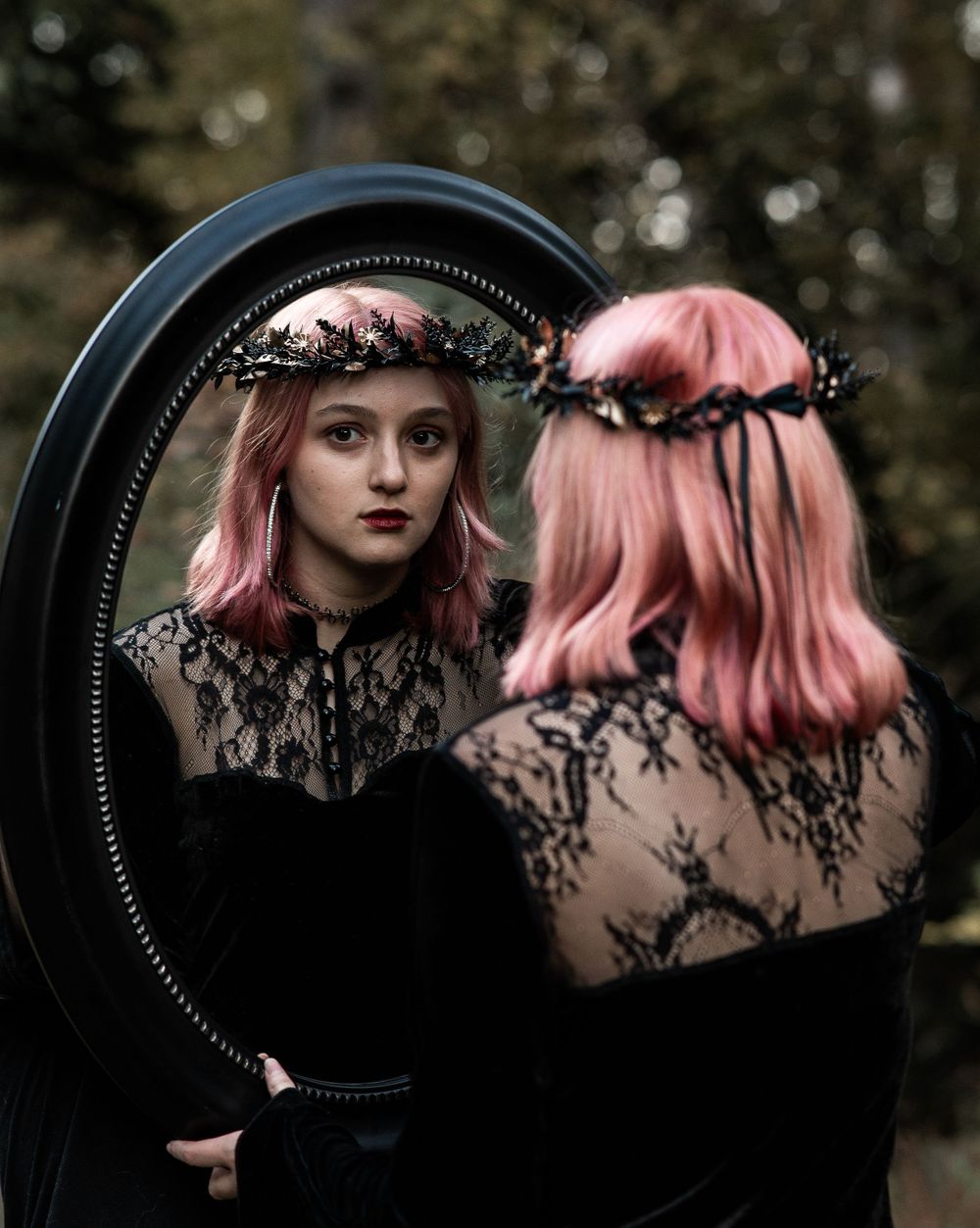 Teen girl looking through her reflection in a mirror in woods, gothic style, Williamston South Carolina