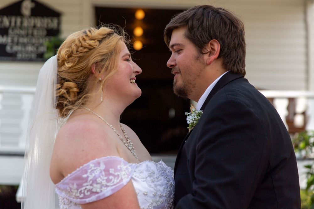 A joyful wedding moment captured in front of an antique building entrance.