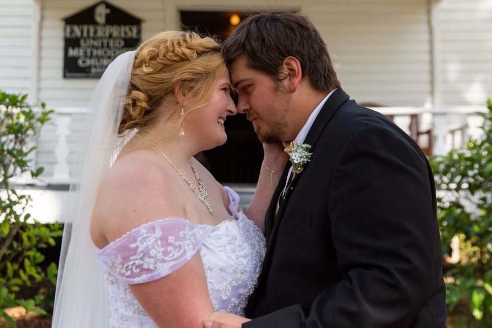 An intimate wedding portrait showing a sweet moment between newlyweds on a charming porch.
