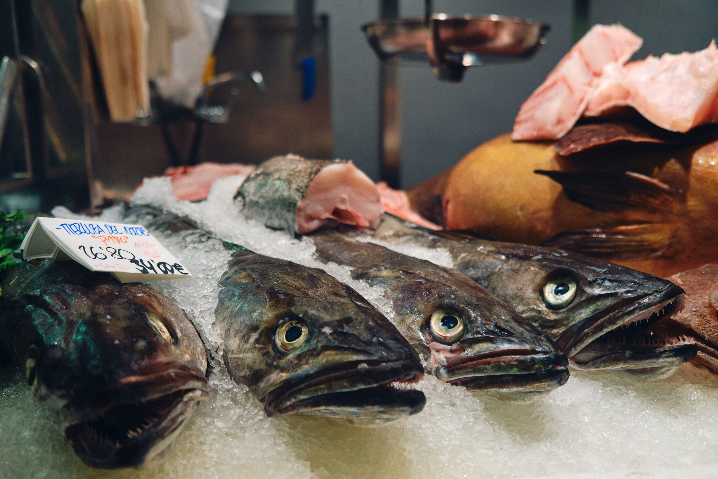 Fresh whole fish arranged on ice at market display.