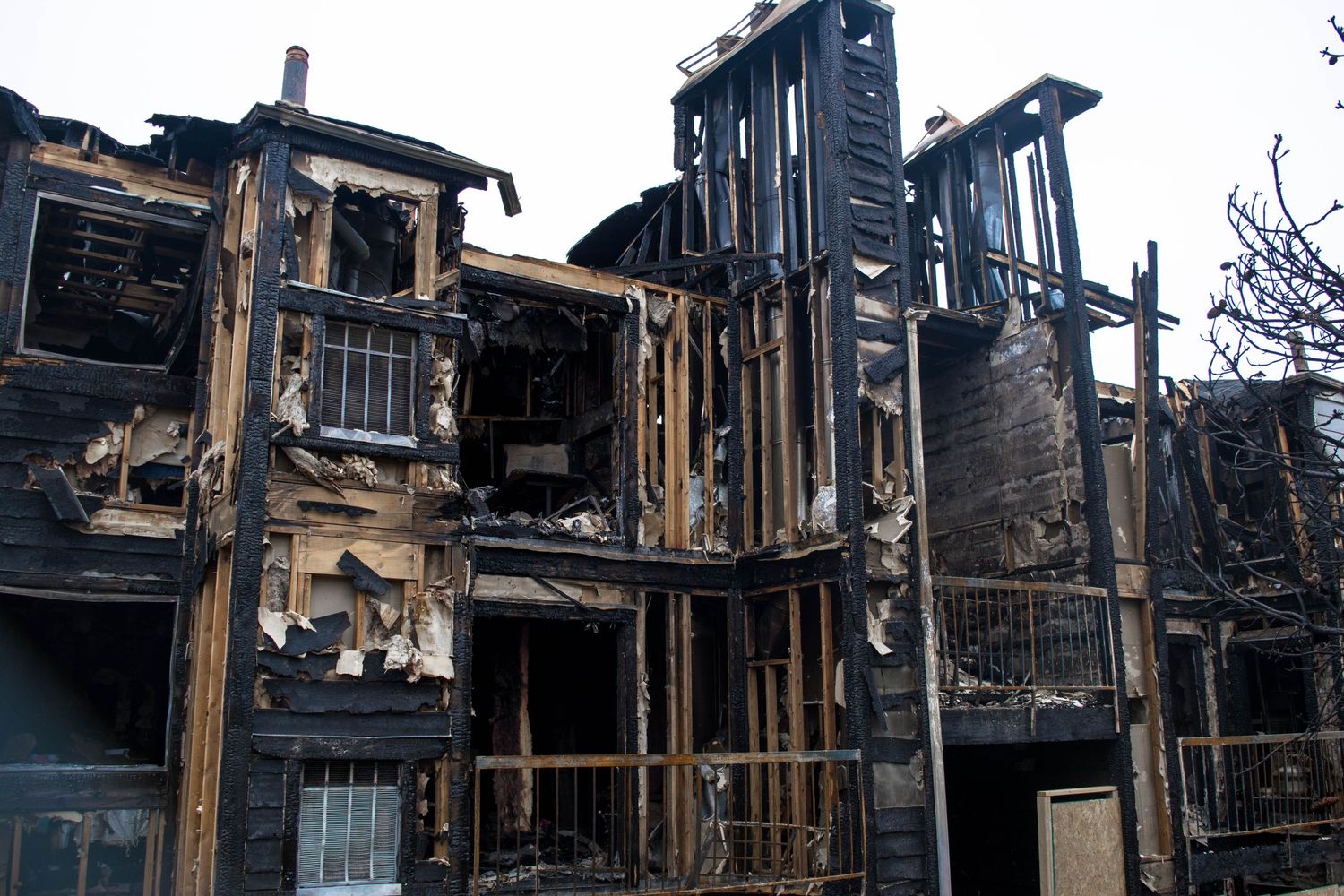 Skeletal remains of a fire-damaged building with exposed wooden framing and charred walls.