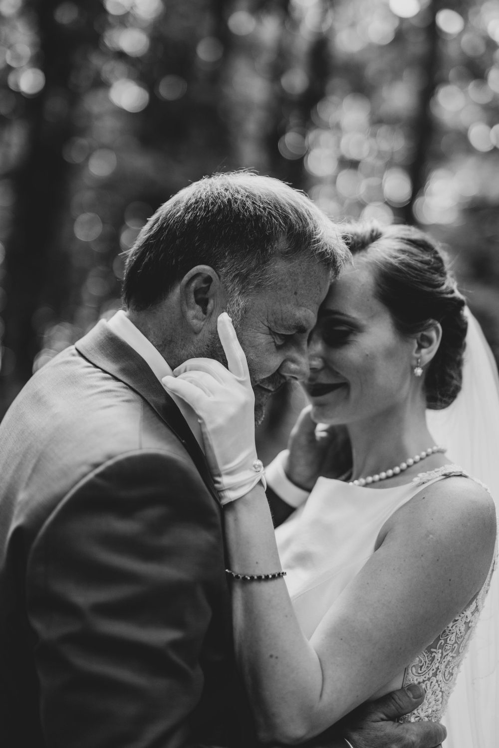 Black and white wedding portrait capturing joyful laughter between newlyweds.