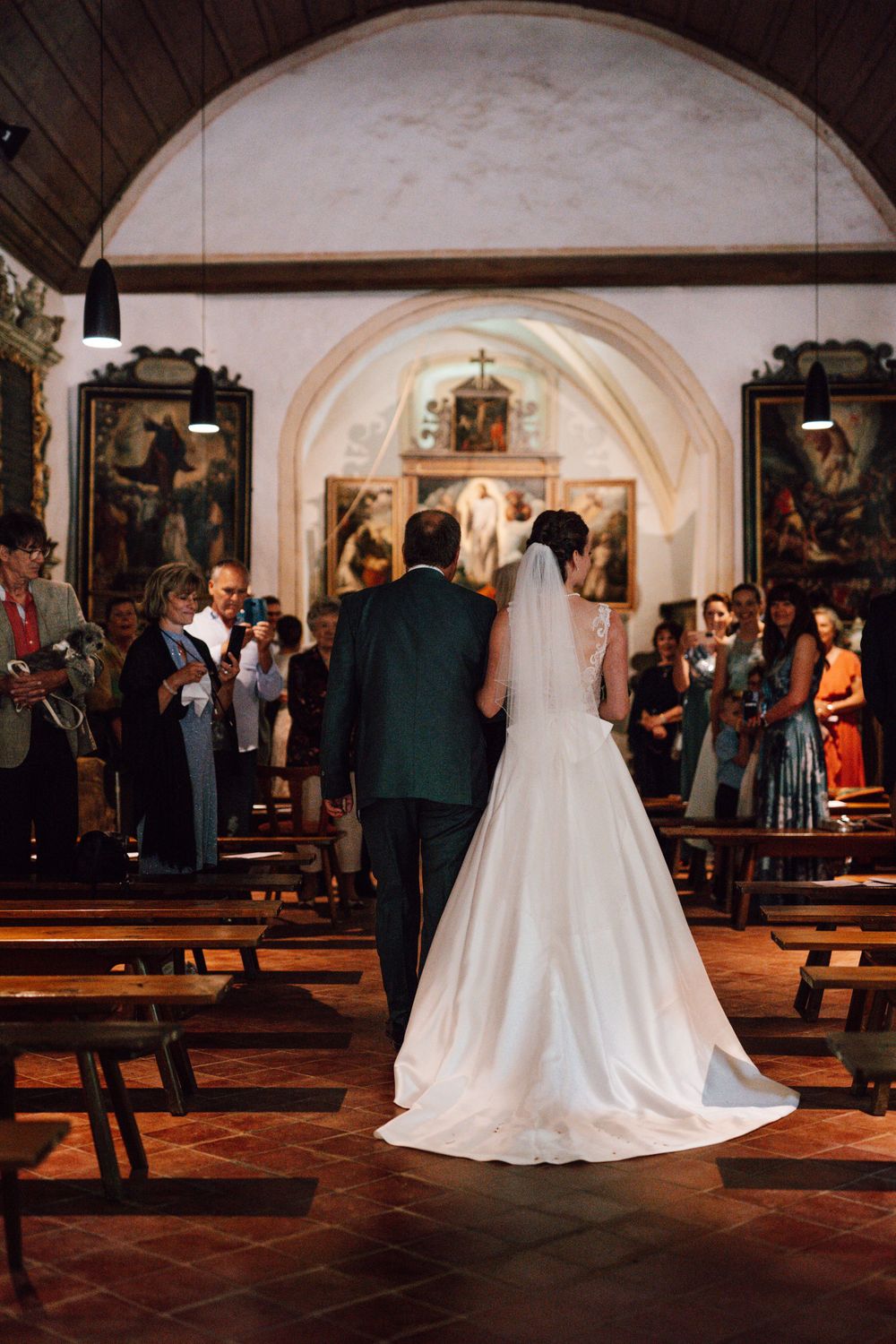 Wedding ceremony in a historic church with arched ceilings and wooden pews.