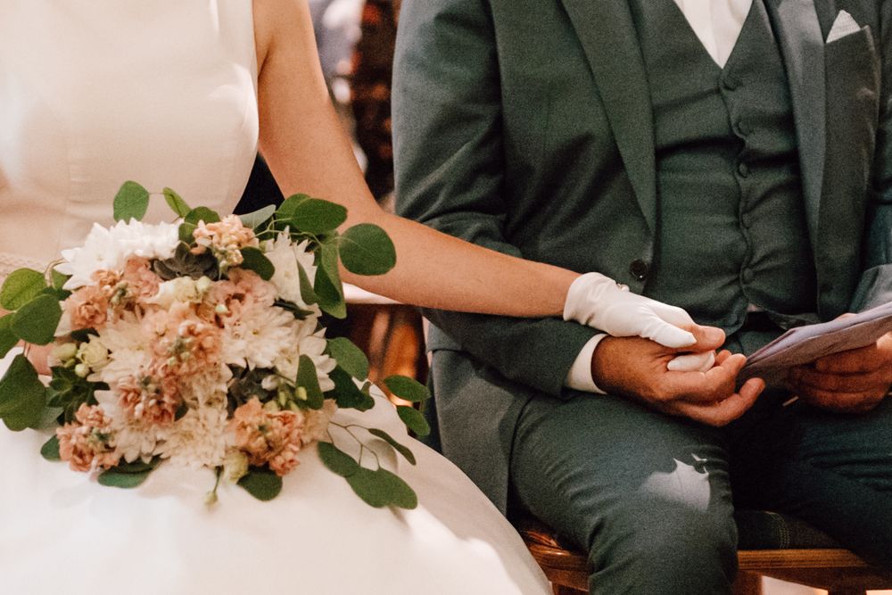 Close-up of wedding bouquet with peach flowers and greenery.