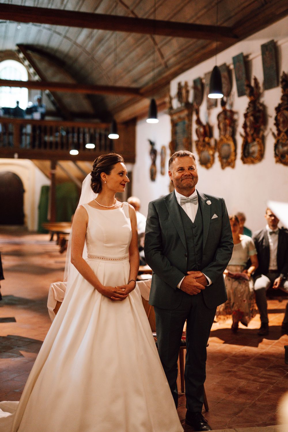 Wedding couple in a rustic venue with wooden ceiling and wall decorations.