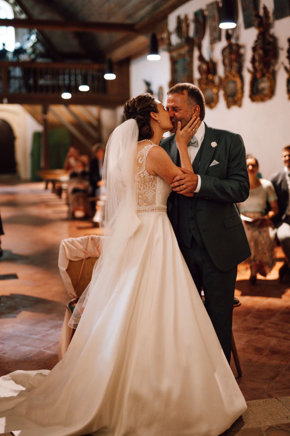 Couple shares their first dance in a rustic venue with traditional wooden wall decorations.