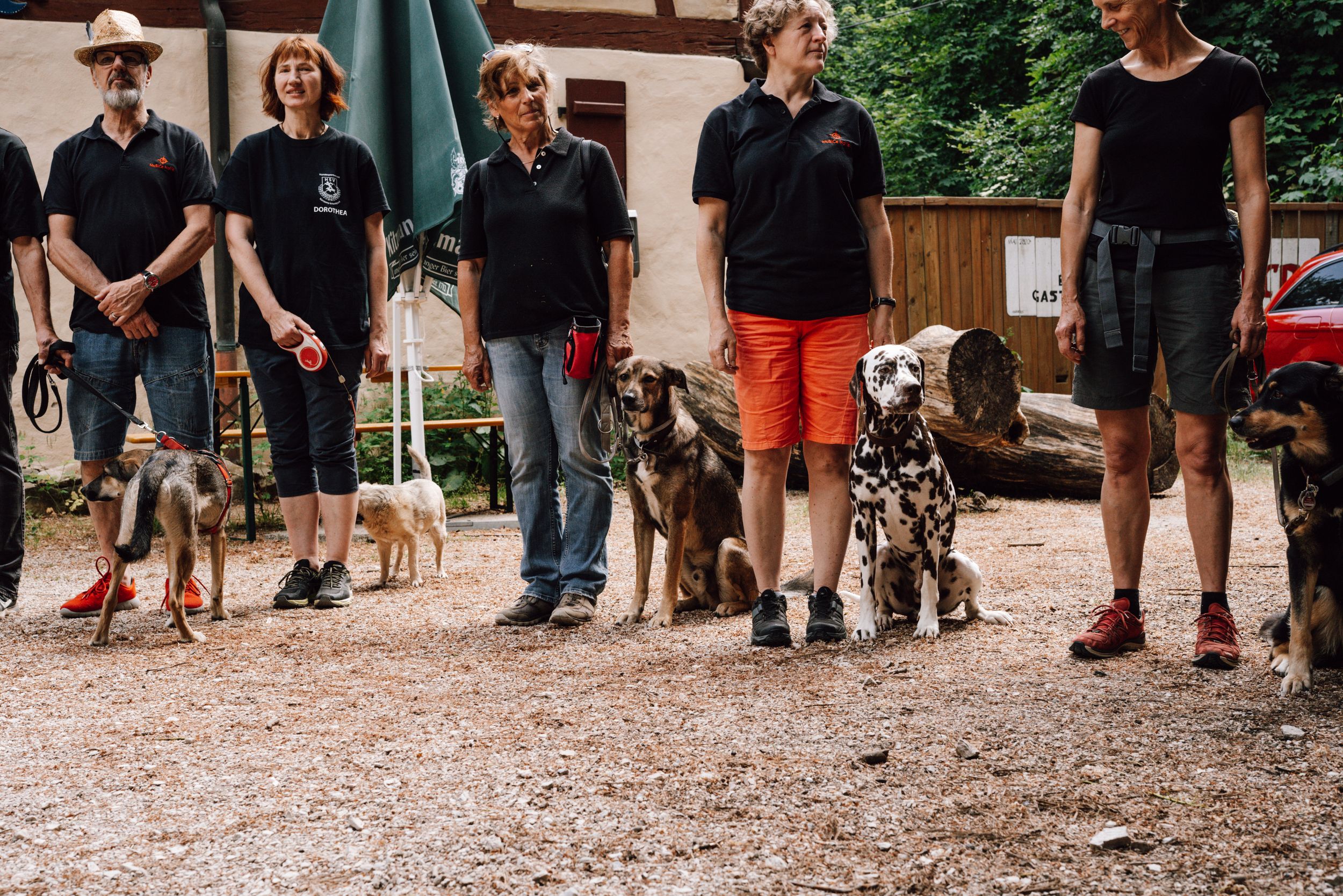 People gathered outdoors on a gravel path for a casual event.