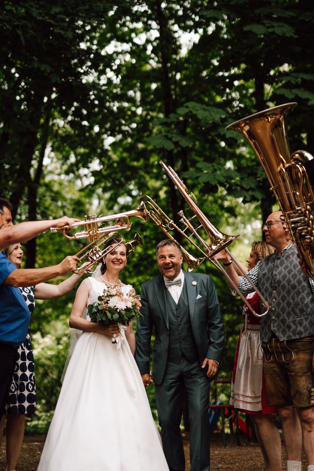 Musicians playing brass instruments during an outdoor wedding celebration.